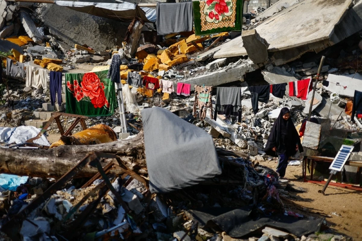 صوره – فتاة فلسطينية تسير أمام أنقاض منزلها المدمر في جباليا، شمال قطاع غزة.