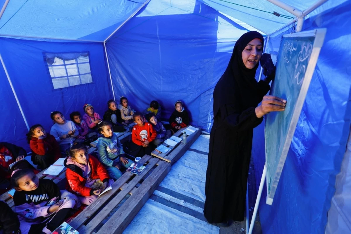 صوره – طلاب فلسطينيون نازحون يدرسون داخل خيمة بالقرب من “الخط الأصفر” الذي حددته إسرائيل في بيت لاهيا شمال قطاع غزة.