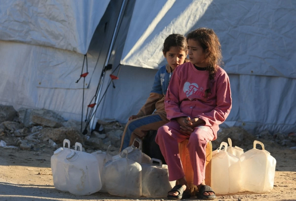 صوره – فتاتان فلسطينيتان تنتظران إعادة تعبئة مياه الشرب في مدينة غزة.
