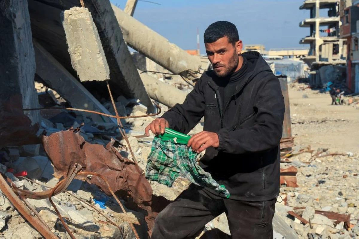 صوره – شاب فلسطيني يبحث عن جثث أفراد عائلته الذين ما زالوا تحت أنقاض منزله المدمر في خان يونس جنوب قطاع غزة.