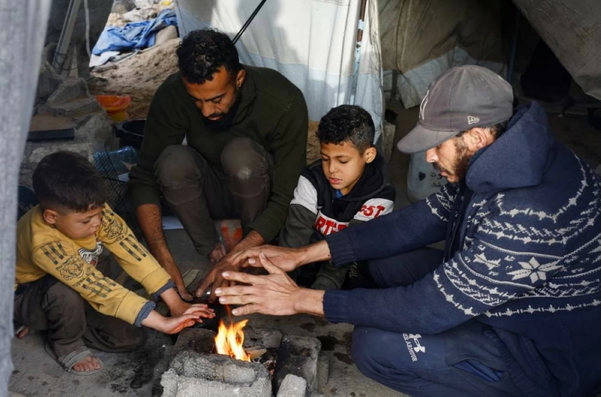 صوره – نازحون فلسطينيون يحرقون الحطب للتدفئة في خيمة في مدينة غزة.
