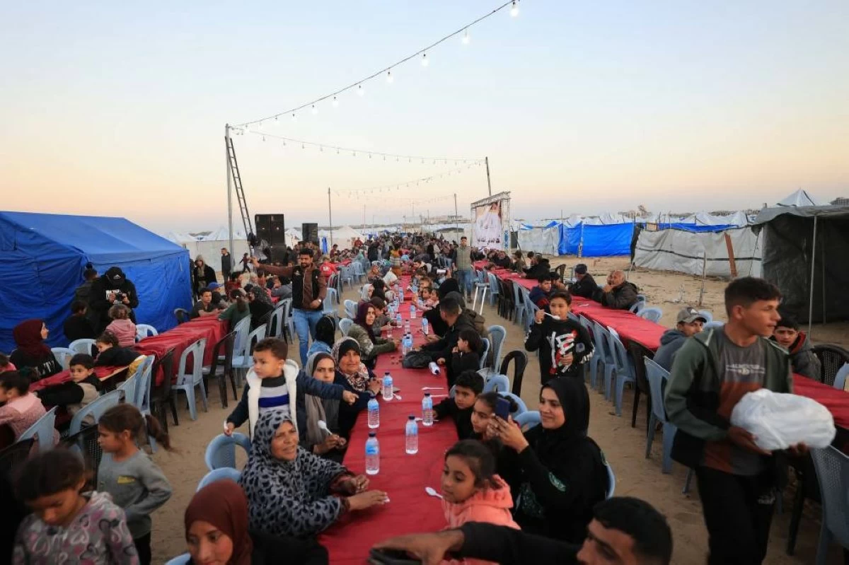 صوره – عائلات فلسطينية نازحة خلال إفطار جماعي في حي الزهراء شمال مخيم النصيرات