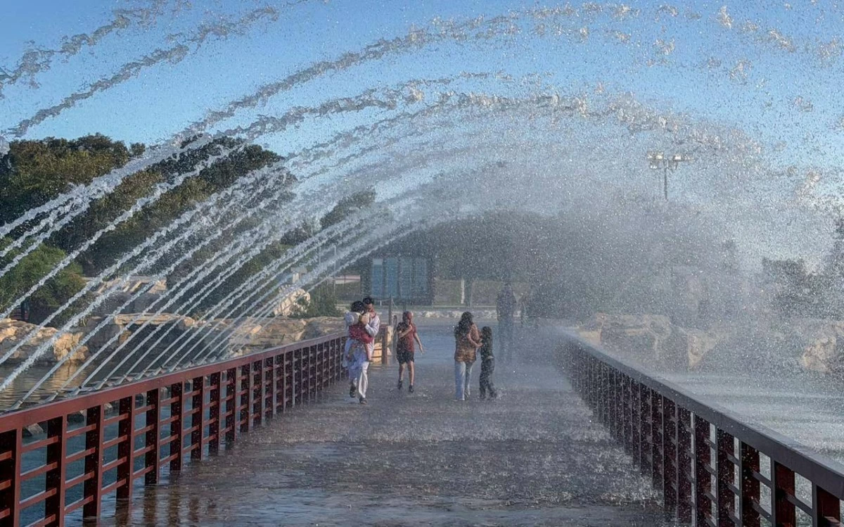 صوره – نافورة بحيرة حديقة أسباير التي تضم على جوانبها مقاهي صغيرة، وأشجاراً ومناظر طبيعية متنوعة.